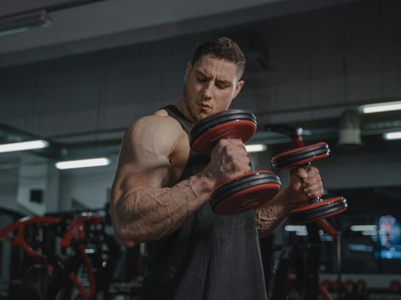 Brawny arm holding a dumbbell in moody lighting
