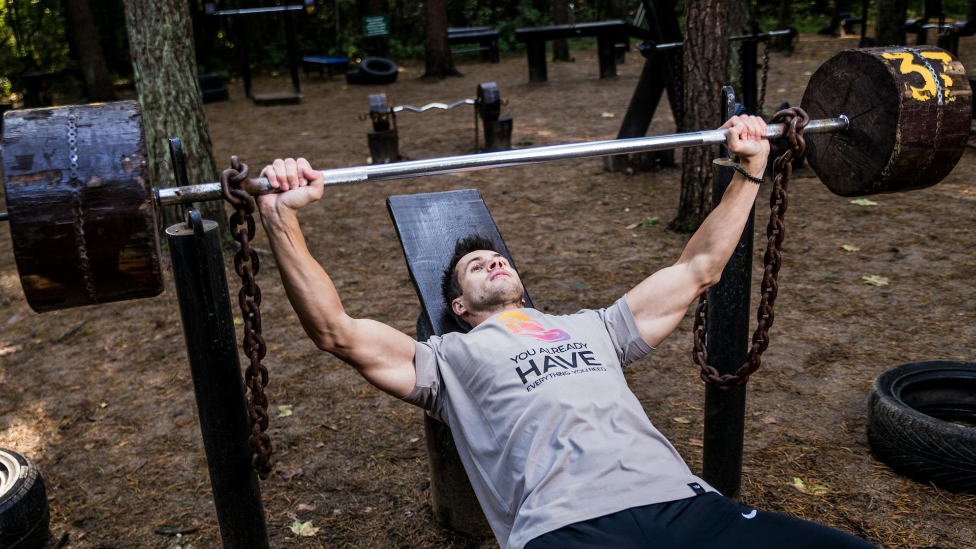 Man focusing on heavy lifting in a dark gym